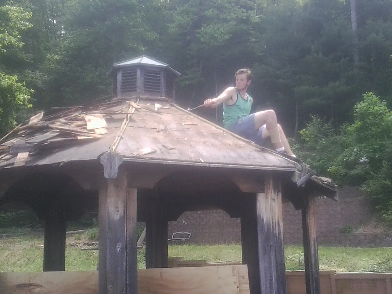 Tearing the old roof off a wooden gazebo before new shakes in Rush Valley
