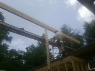 Carpenter setting a ridge beam over a new addition frame — Ice Dam Removal by Roofing Brothers in Rush Valley