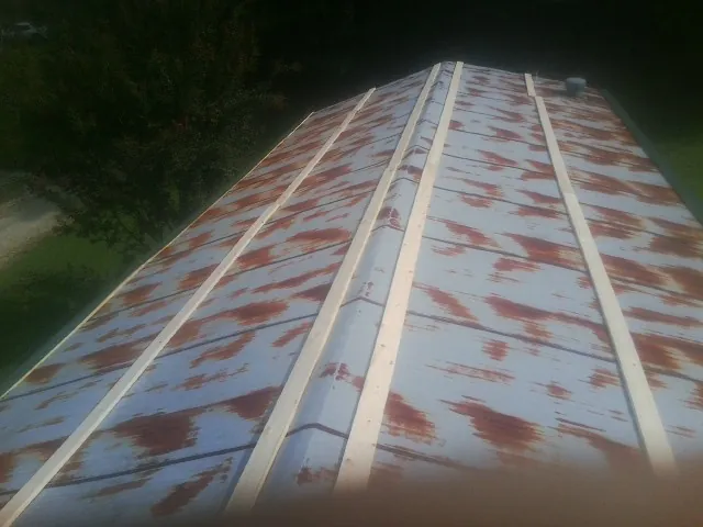 Rusted metal roof panels with new wood purlins before replacement — Storm Damage Roof Repair in Rush Valley by Roofing Brothers