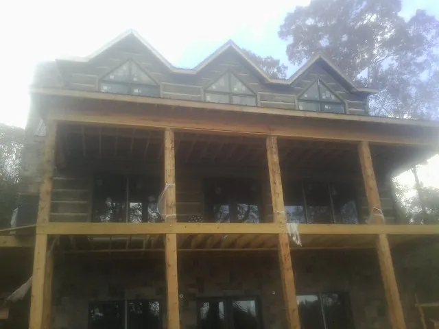 Dormers and porch framing on a large log home under construction — Roof Coating work by our crew in Rush Valley