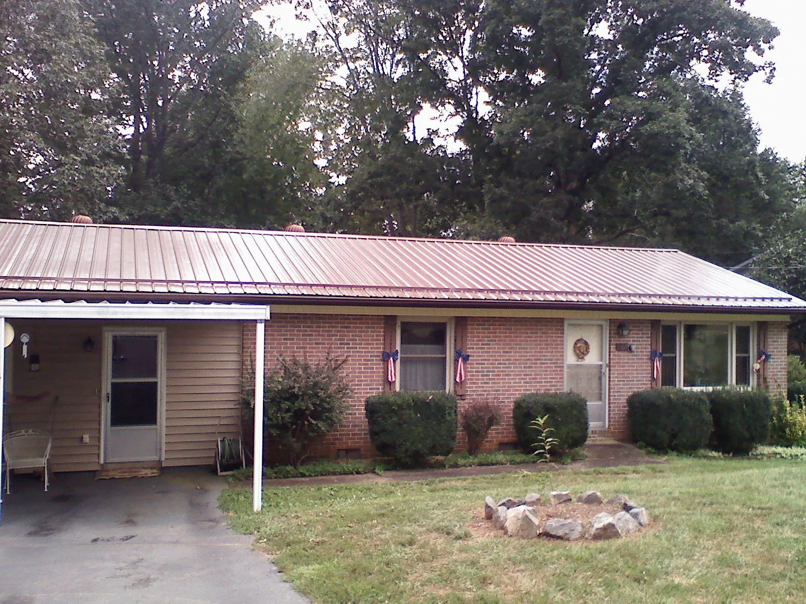 Bronze metal roof and carport on a brick ranch home — Roof Repair work by our crew in Rush Valley