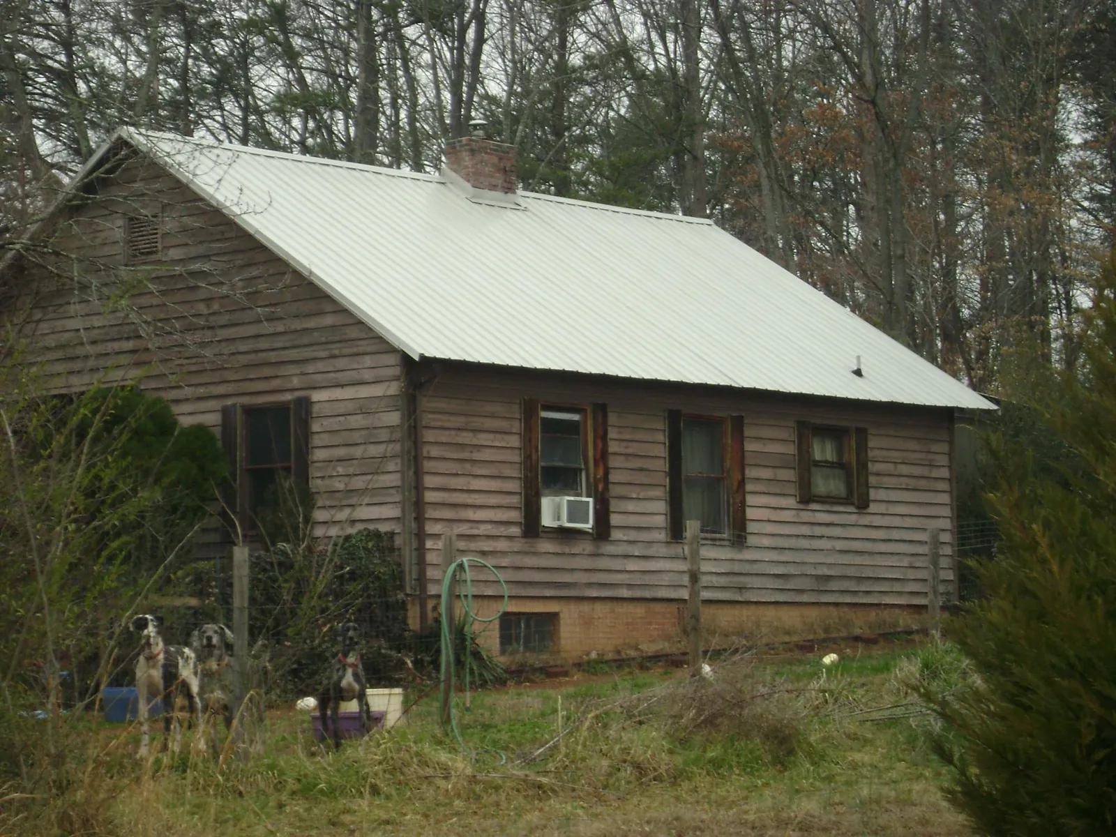 White metal roof on an old wood sided farmhouse, from a Metal Roof Installation job in Rush Valley